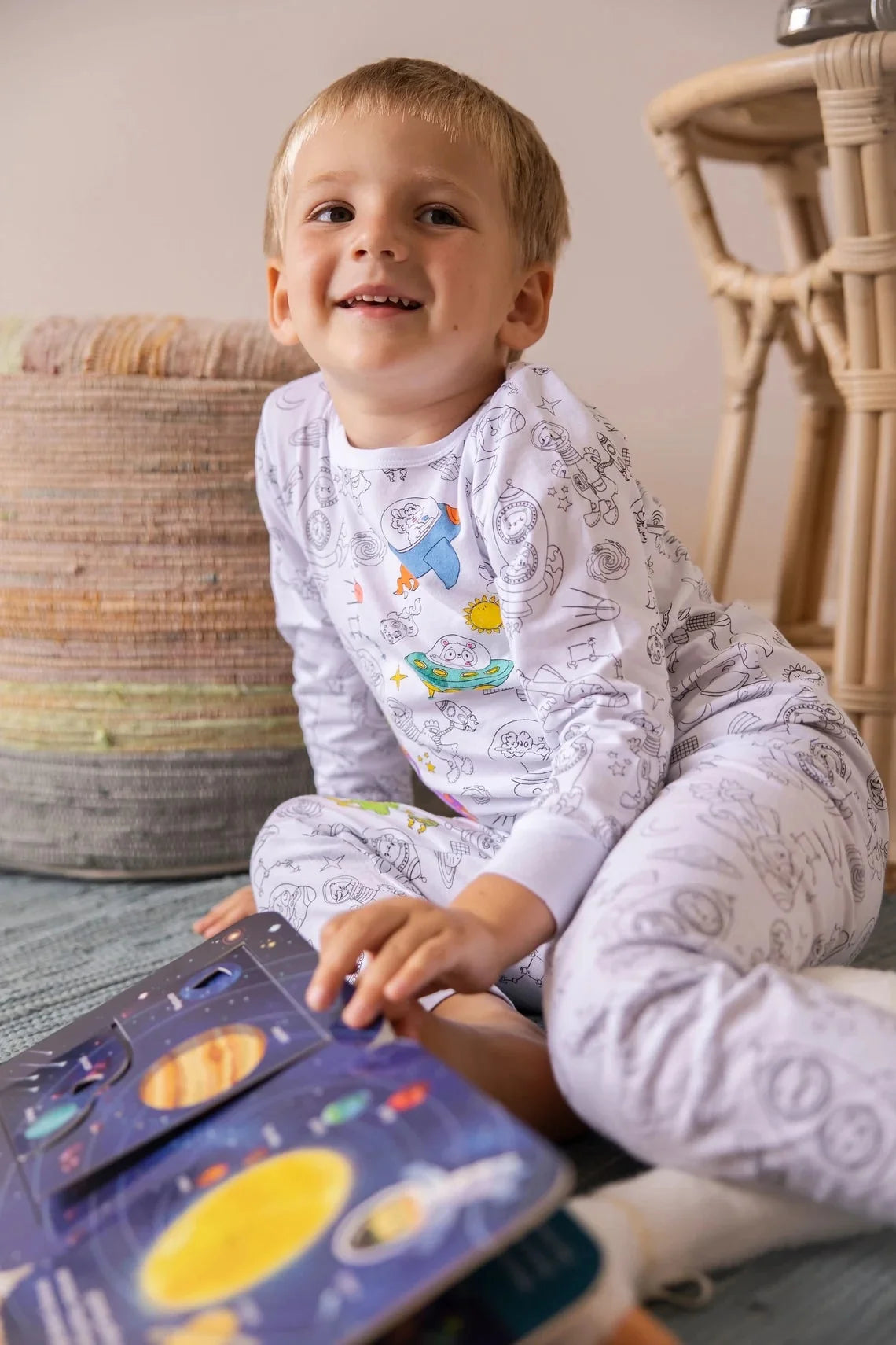 Photo of the smiling kid with the book, in coloring pajama Henry the Goose